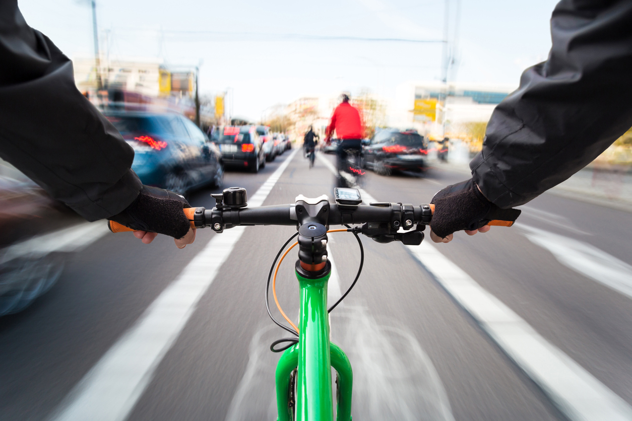 Cyclist drives on the bike path past the traffic jam – First-person view of cyclist/ motion blur