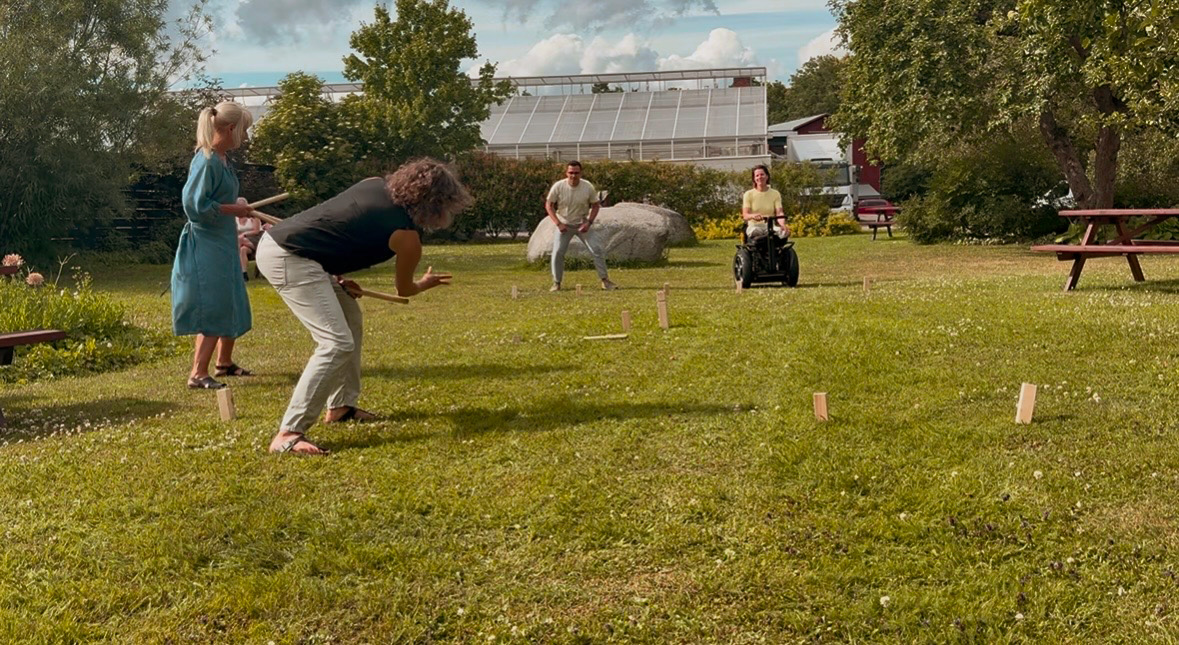 personer som spelar kubb, däribland en som sitter i rullstol